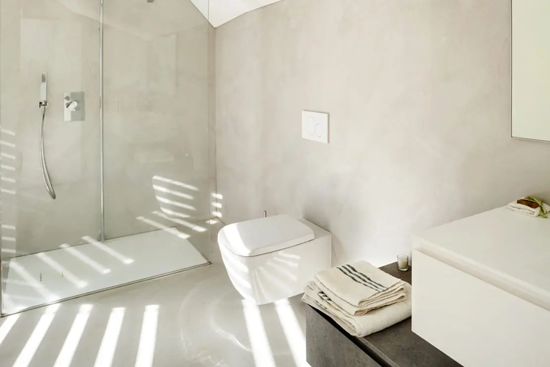 Baño con suelo y paredes de microcemento en color claro